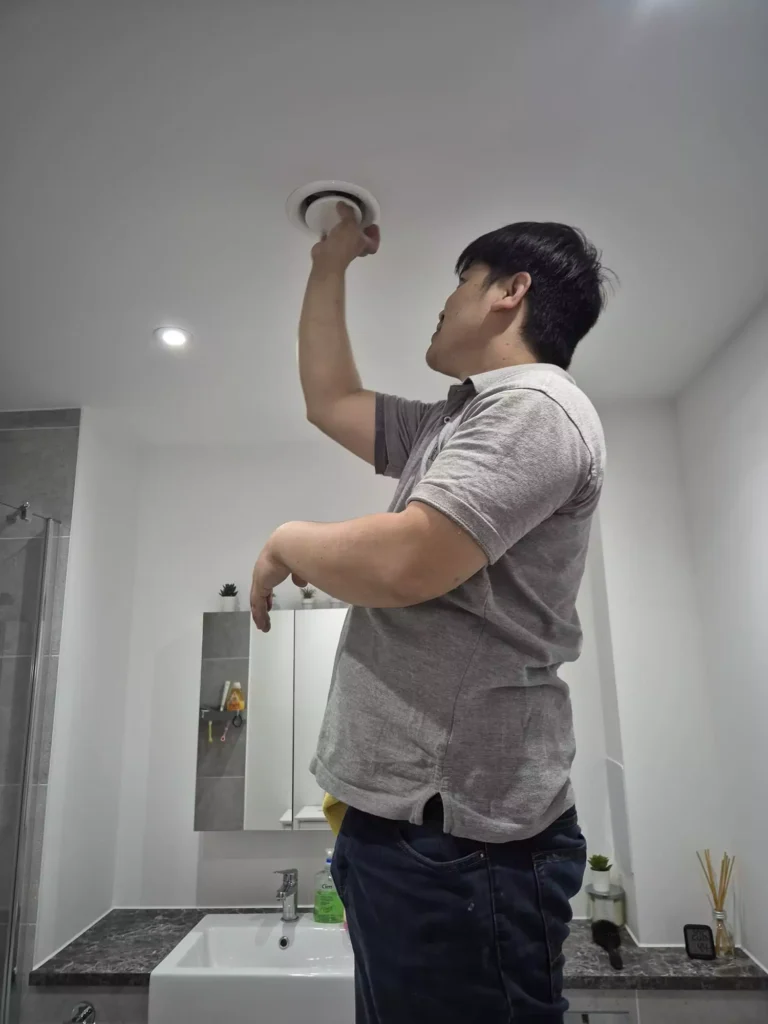 One of our technicians working on a bathroom ventilation system.